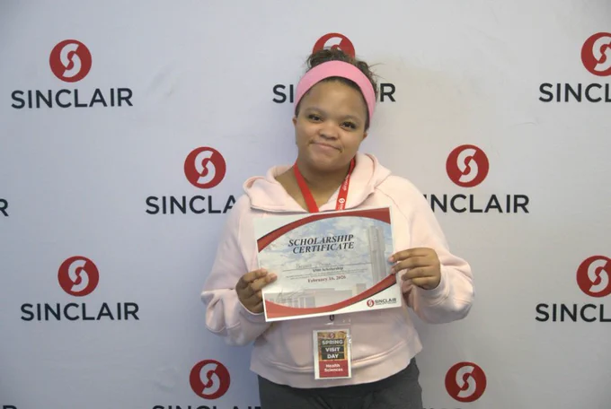 Scholarship winner standing with award.