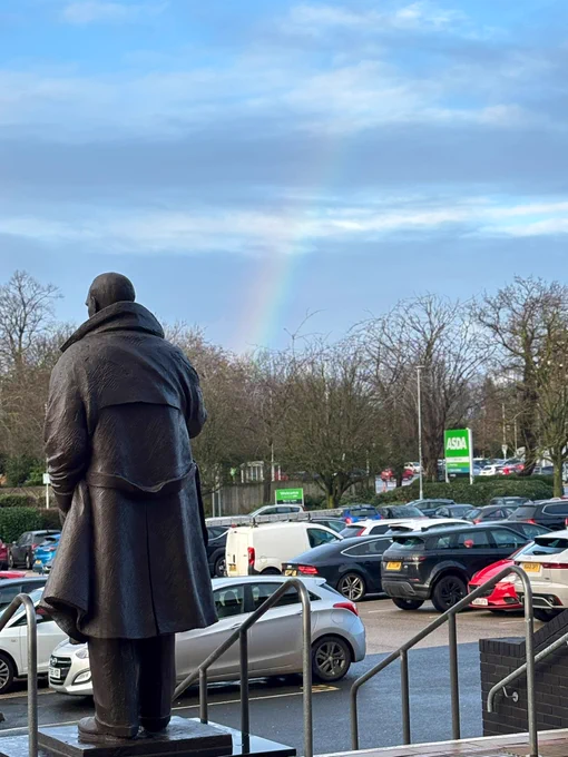 Statue of Stan Cullis. There is a rainbow in the background.
