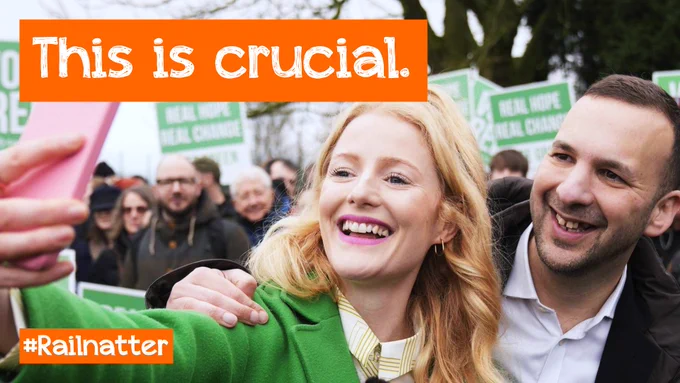 a youtube thumbnail, showing a smiling Hannah Spencer and Zack Polanski taking a selfie in front of a group of Green Party activists, with the words "This is crucial" superimposed on top