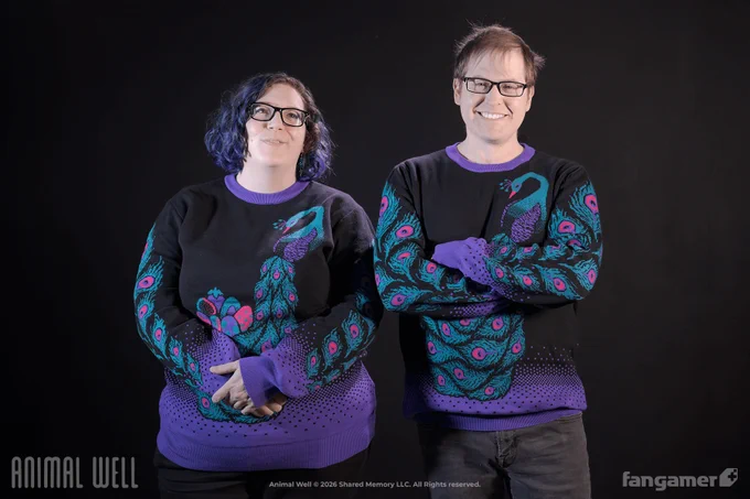 Two people wearing the Peacock's Treasure knit sweater. It's a black sweater with a purple gradient at the bottom and a purple collar; a large, muted purple, pink, and green knit peacock design is wrapped across the sweater. 