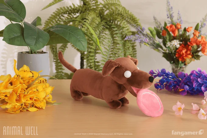 A photo of a plush wiener dog with totally white eyes holding a pink plush flying disc in its mouth. 