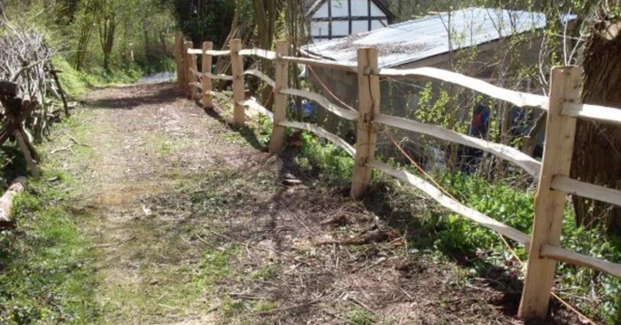 Hardwood post and rail fencing along a track.
