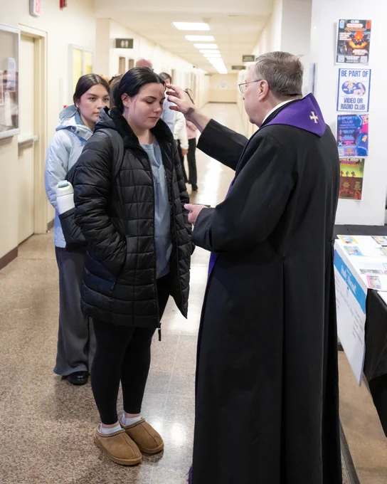 Fr. Greg Fluet distributes ashes to the Mount community on Ash Wednesday.