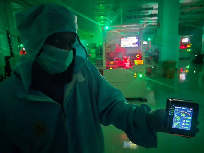 Cleanroom air quality monitor displaying AQI 0, indicating zero detectable particulate contamination inside a dark factory semiconductor facility.