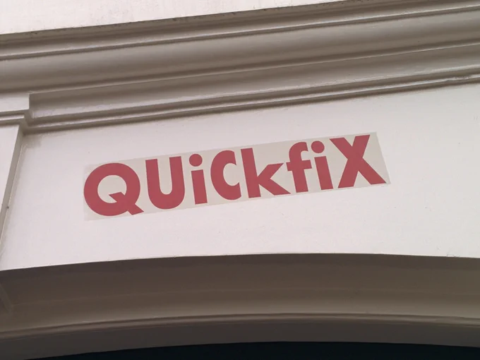 A sign reading "QUiCkfiX" is displayed on a white wall, suggesting a focus on quick solutions or repairs.
