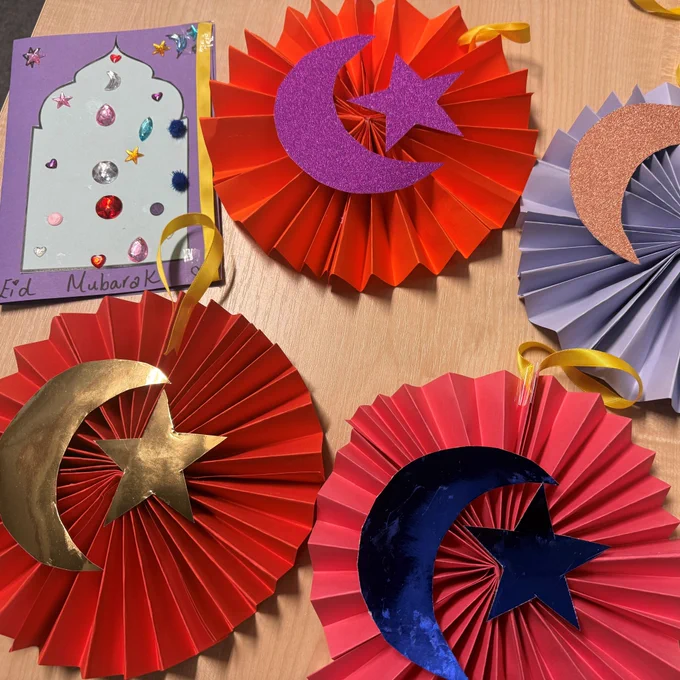 Red and purple paper fans and cards decorated with paper crescents and stars