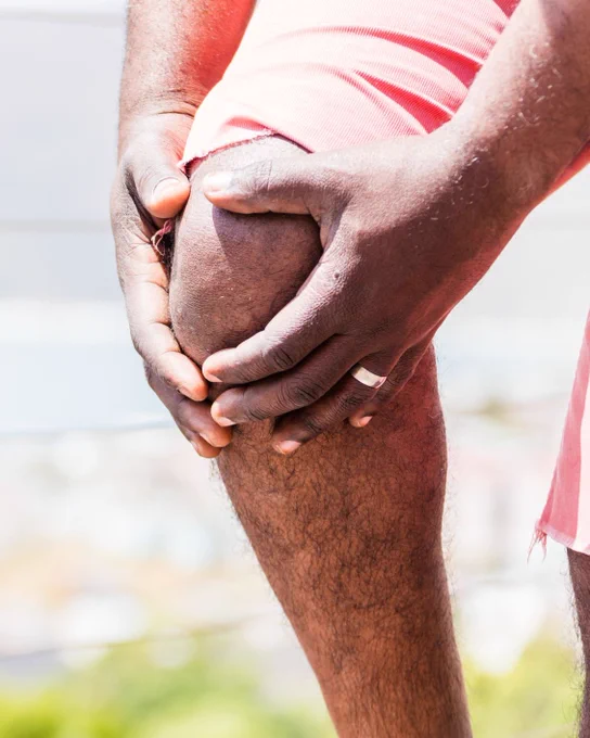 Man holding his knee in pain. 