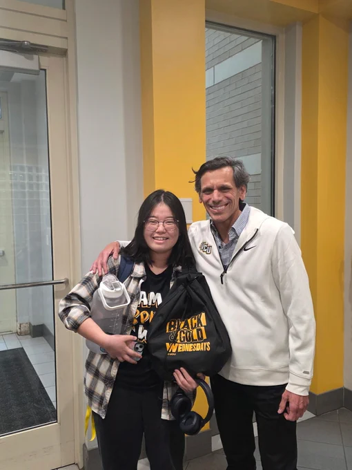 Dr. Rao poses with a student holding a Black & Gold Wednesdays drawstring bag.