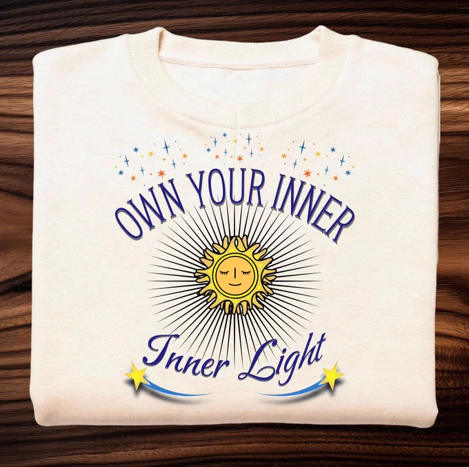 Own your inner light navy blue text on cream t-shirt with the sun graphic