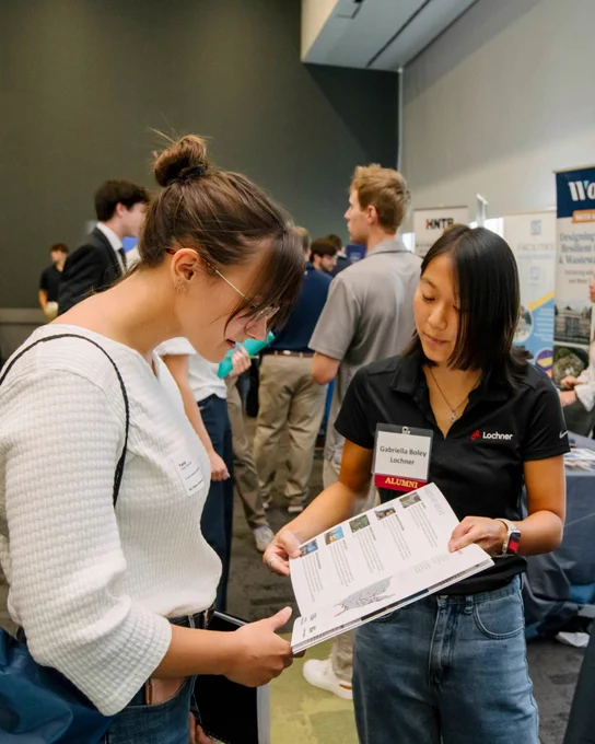 A student and recruiter looking at a flyer at NC State's Career Connections.