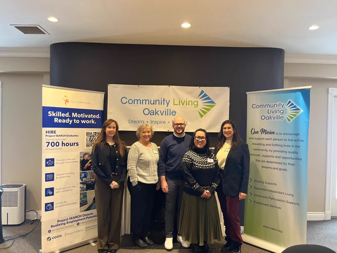 Event organizers from Halton Healthcare, Community Living Oakville, the Ontario Disability Employment Network, and Project SEARCH Canada stand in front of banners for Community Living and Project SEARCH