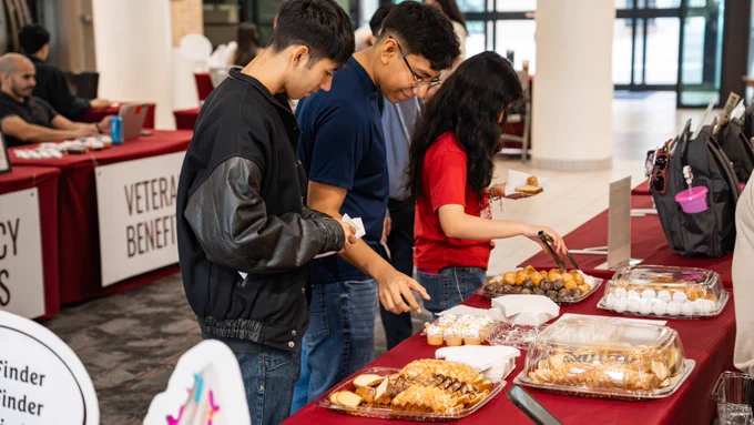 Students at the sweet bread booth picking which treat they might like.