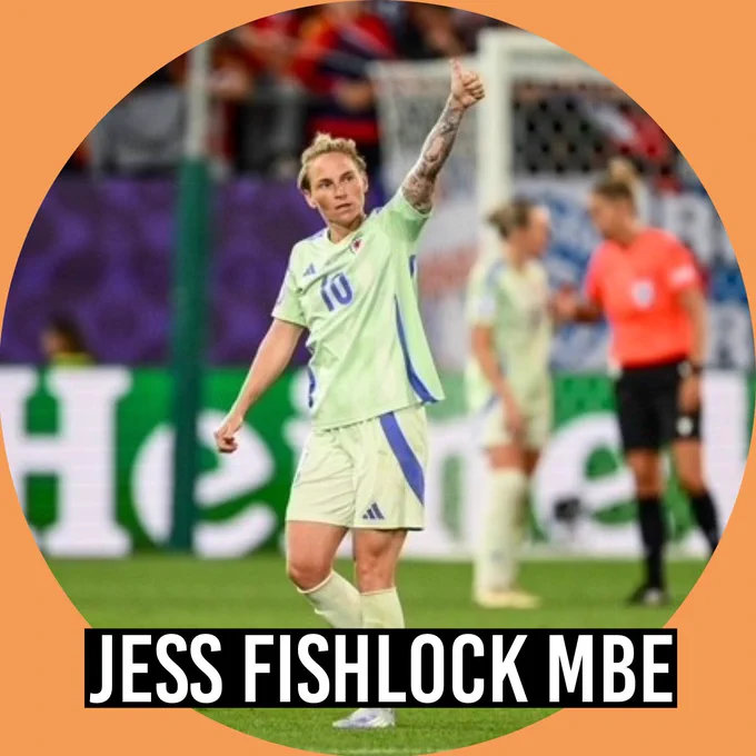 Jess Fishlock in a light green football kit giving a thumbs-up gesture on the pitch during a match, with blurred players and a referee in the background