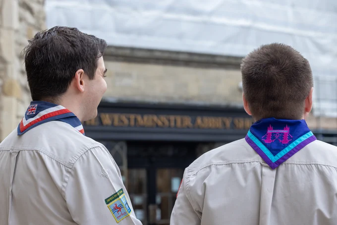 Two people wearing Scout uniforms standing outside Westminster Abbey