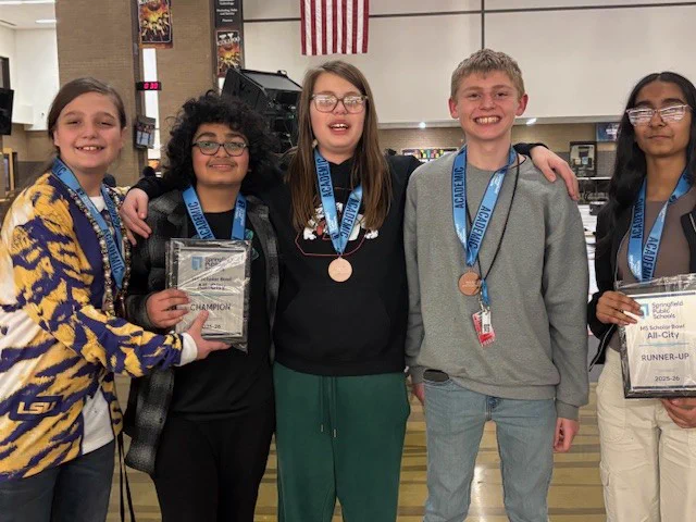Group of five students wearing medals around their necks and holding two plaques