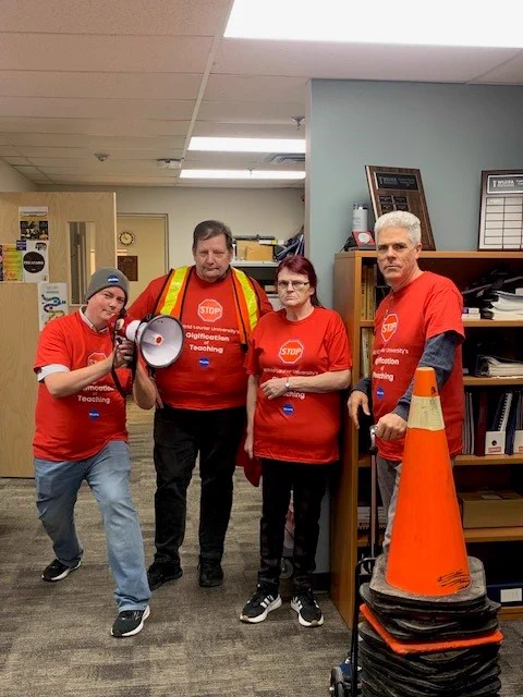 WLUSA President donating traffic pylons and reflective vest to WLUFA. All in photo wearing new red Contract Faculty Solidarity Shirts. Ryan Ladner with the WLUFA Bullhorn