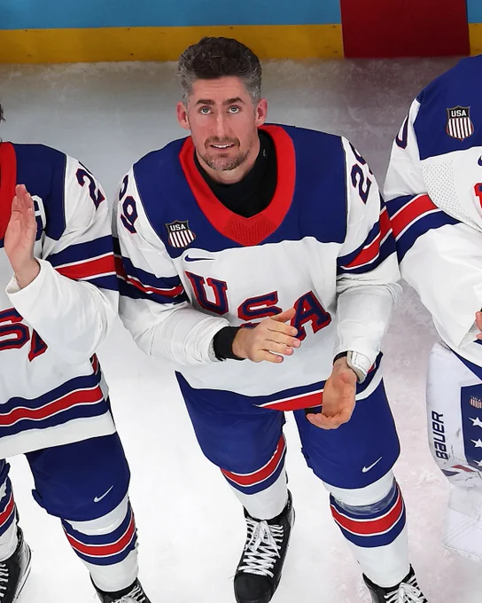 Brock Nelson on ice in a USA uniform celebrating USA's gold medal victory.