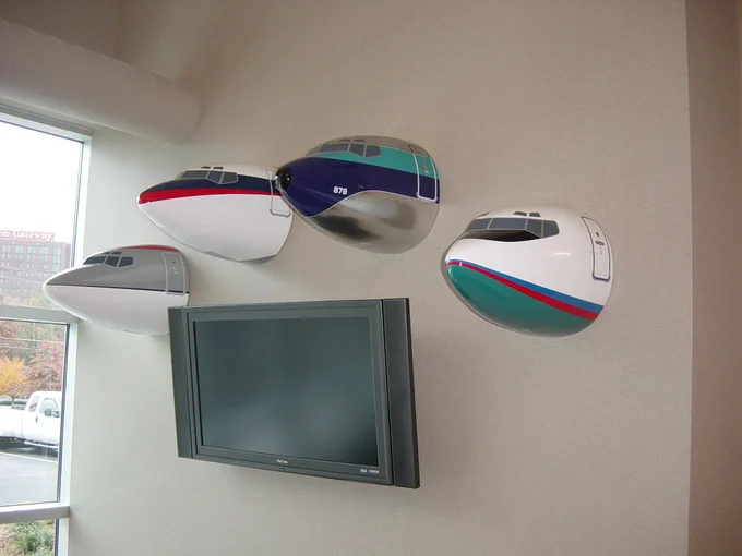 four airplane noises hung on a wall surrounding a flat screen tv.