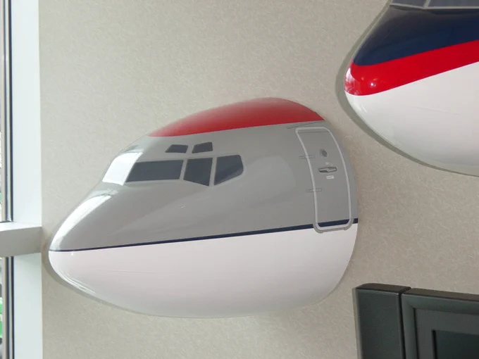 Small airplane nose hung on a wall.