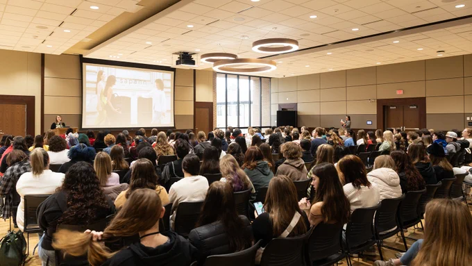 TMFD Chair Jennifer Johnson Jorgensen welcomes a large room full of students to the keynote session of the TMFD Expo