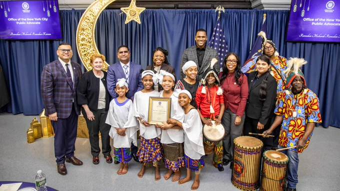 Team members and elected officials pose with Elected officials and staff pose with Ifetayo Cultural Arts Academy drummers and dancers