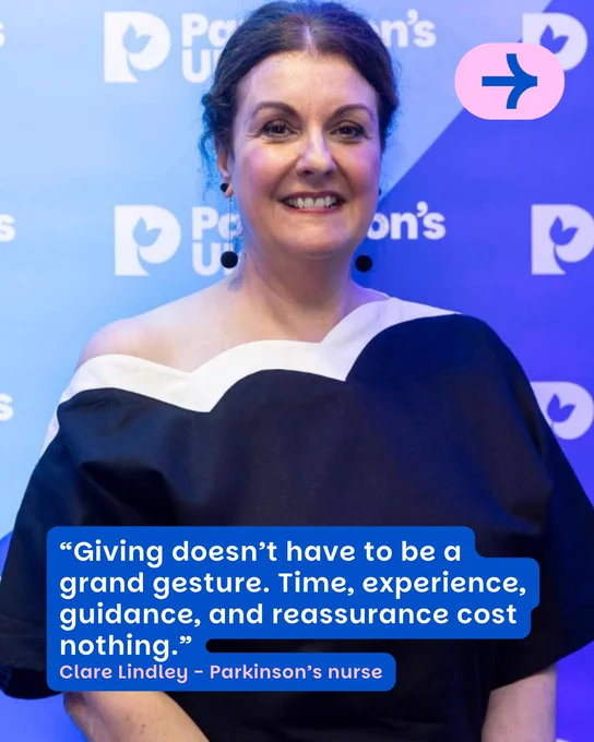 This image shows a person smiling in front of a Parkinson's UK backdrop. They are wearing a dark outfit with a white neckline. A quote is displayed on the image: "Giving doesn't have to be a grand gesture. Time, experience, guidance, and reassurance cost nothing." Below the quote, it says: "Clare Lindley - Parkinson's nurse."