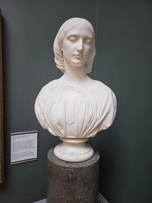 White marble bust of Josephine Butler with a dark grey / green background