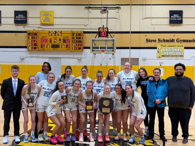 Mid Michigan Women's Basketball team stand for a picture celebrating their Championship win!