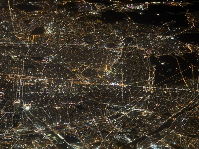 View of the lit Eiffel Tower at night from 37.000ft. And of course part of the inner city of Paris.