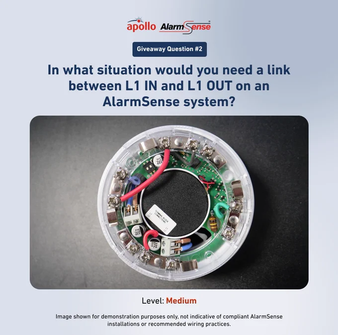 Close-up of an AlarmSense device's internal wiring showing connections for L1 IN and L1 OUT terminals on a circular circuit board.
