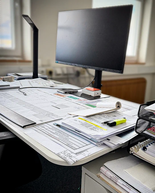 Desk with documents and notebook during aircraft development review.