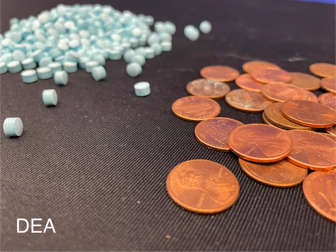 Pennies on right side of photo; blue pills to the left