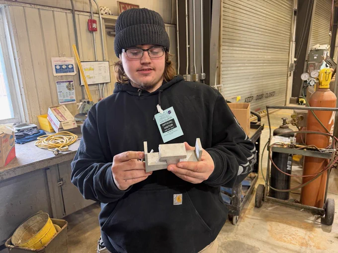 A student examines a component in a NASA Wallops workshop.