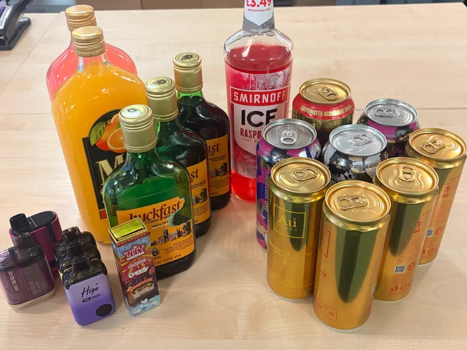 An array of empty and full alcohol containers and vapes.
