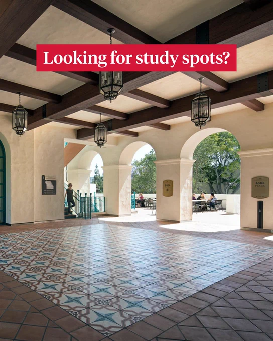 A spacious corridor with arched openings, decorative tiled floor, and hanging lanterns provides shade for a sunny outdoor seating area. A sign reads "Looking for study spots?" in red at the top.