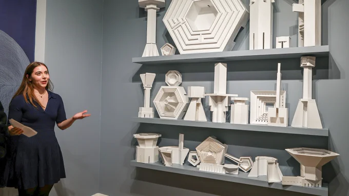 A female student presents a work of paper sculpture in the "speculative morphologies" exhibition.