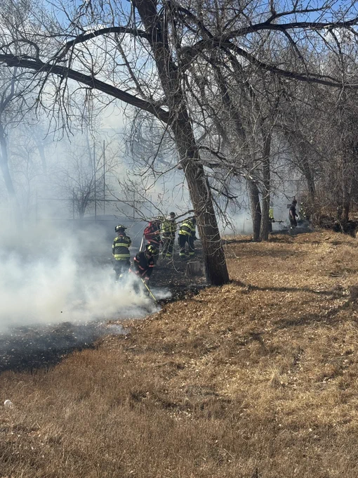 Firefighters working a grass fire, lots of white smoke