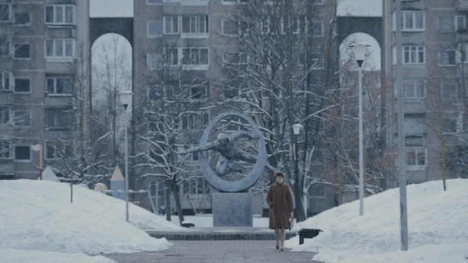 From Star City, a female walks outside next to a  monument in the Star City town center.