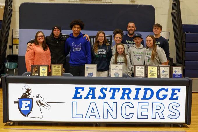 students stand with families