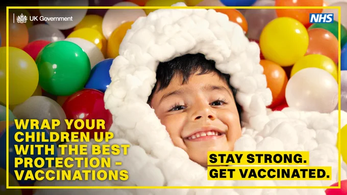 Image of a child in a fluffy jacket inside a ball pit. Text says: wrap your children up with the best protection - vaccinations. Stay strong, get vaccinated.