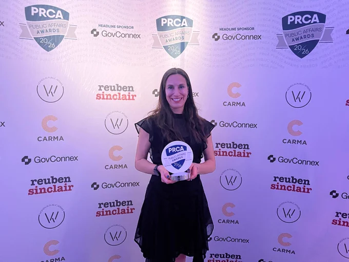 Jo Field OBE, Founder and CEO of JFG Communications standing smiling at the camera, holding the award for PRCA Public Affairs Woman of the Year.