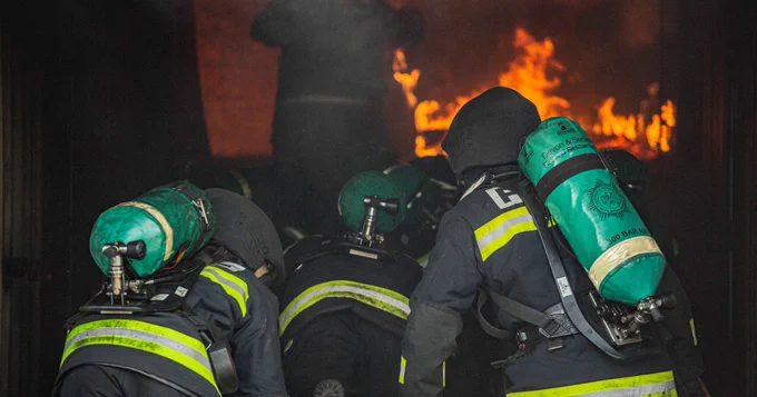 Firefighters undergoing breathing apparatus training in a container