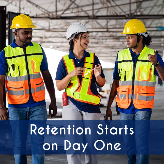 Three industrial workers in safety gear walking and talking in a Puget Sound warehouse, showing teamwork and employee engagement.