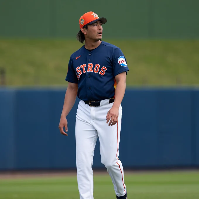 Tatsuya Imai walks on the field. He is wearing a navy Houston Astros jersey with orange lettering, white pants and an orange Houston Astros cap.