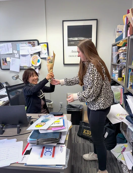 A Mount Saint Mary College student surprises an appreciative professor with a hand-delivered bouquet.