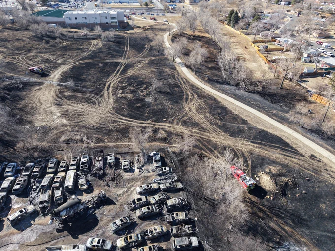 Aerial view of fire burn showing cars.