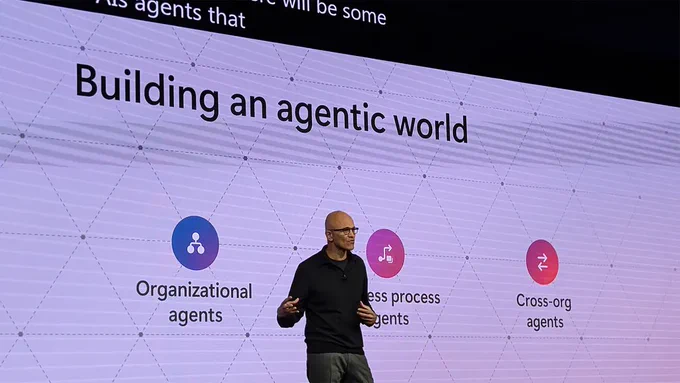 Microsoft CEO Satya Nadella speaking in front of a large screen
