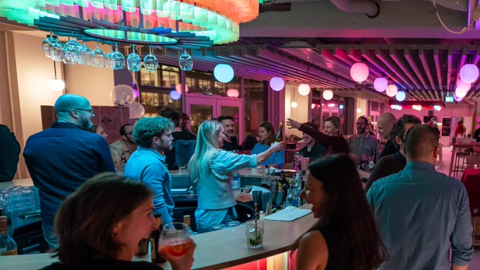 A office bar filled with people an colorfull lights