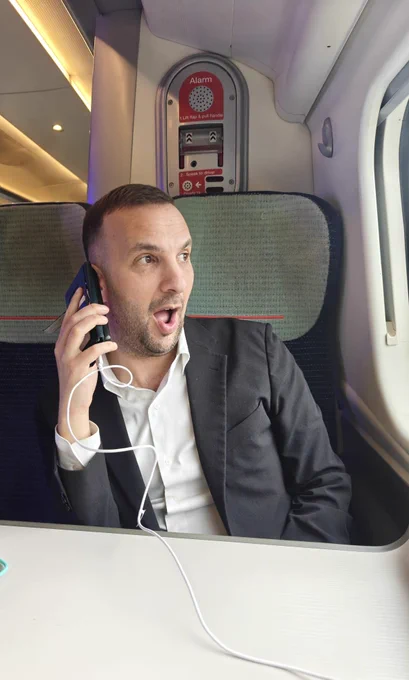 Zack on a train on the phone