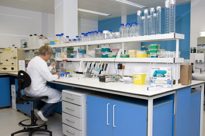 Person in a lab coat sat working in a lab